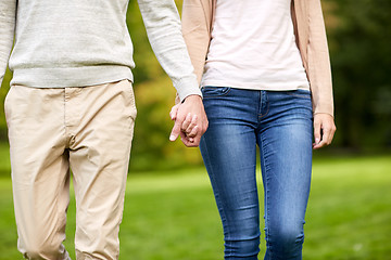 Image showing close up of happy couple holding hands in park