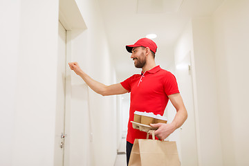 Image showing delivery man with coffee and food knocking on door