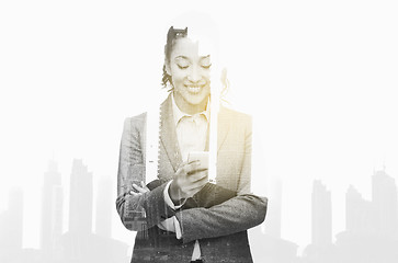 Image showing smiling businesswoman looking at smartphone