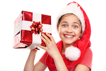 Image showing Christmas dreams, magical Christmas time Happy child in the cap of St. Nicholas of packaged gift 