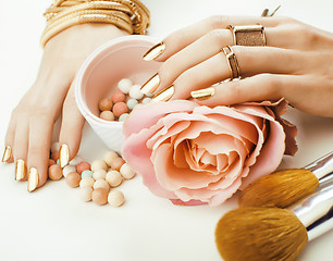 Image showing woman hands with golden manicure and many rings holding brushes, makeup artist stuff stylish, pure close up