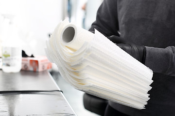 Image showing A tattoo artist preparing disposable paper towels.   Hygiene in the tattoo parlor.