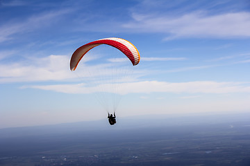 Image showing Paraglider flies in the blue summer sky