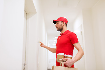 Image showing delivery man with coffee and food ringing doorbell