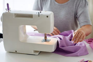 Image showing tailor woman with sewing machine stitching fabric
