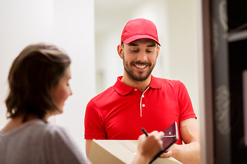 Image showing delivery man with box and tablet pc at customer