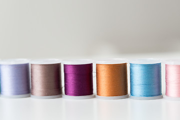 Image showing row of colorful thread spools on table