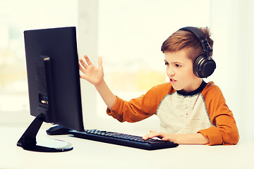 Image showing boy with computer and headphones at home