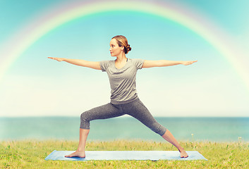 Image showing woman making yoga warrior pose on mat