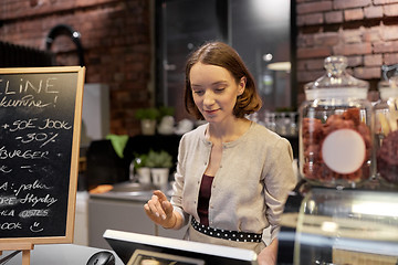 Image showing happy woman or barmaid with cashbox at cafe