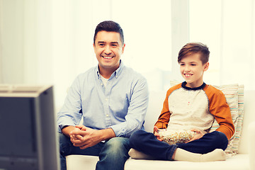 Image showing smiling father and son watching tv at home