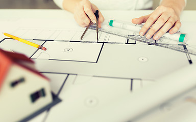 Image showing close up of hands with compass measuring blueprint