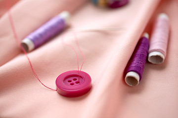 Image showing sewing buttons, spools of thread and cloth