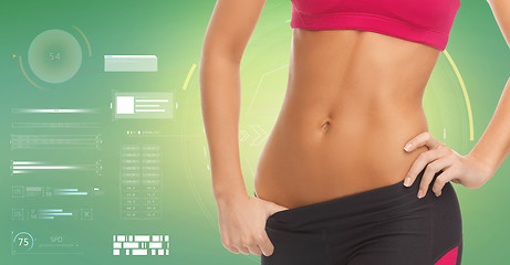 Image showing close up of sporty woman abdomen over green