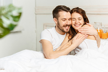 Image showing Young adult heterosexual couple lying on bed in bedroom