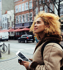 Image showing young pretty african american girl with curly hair making photo on a tablet, lifestyle people concept, tourist in european german city