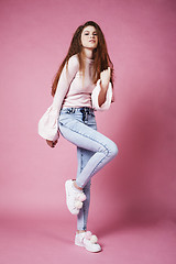 Image showing young pretty red hair ginger girl jumping isolated on pink background, lifestyle flying teen people happy smiling concept 