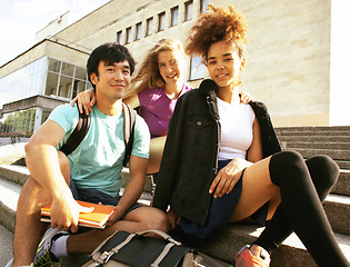 Image showing cute group of teenages at the building of university with books 