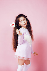 Image showing little cute girl with candy on pink background posing emotional, lifestyle people concept 