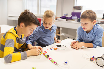 Image showing happy children building robots at robotics school