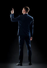 Image showing businessman in suit touching something invisible