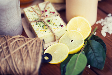 Image showing close up of natural soap and candles on wood