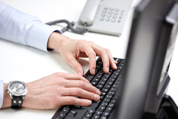 Image showing close up of male hands typing on computer keyboard