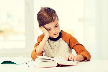 Image showing student boy reading book or textbook at home