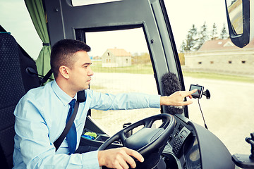 Image showing bus driver entering address to gps navigator