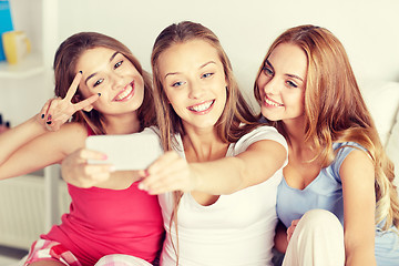 Image showing teen girls with smartphone taking selfie at home