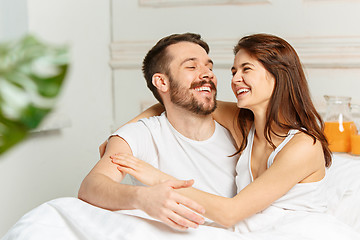 Image showing Young adult heterosexual couple lying on bed in bedroom