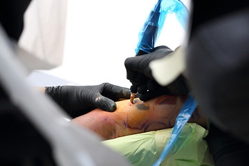 Image showing Tattoo Studio. Decorating the skin tattooed. Colored tattoo on his hand.