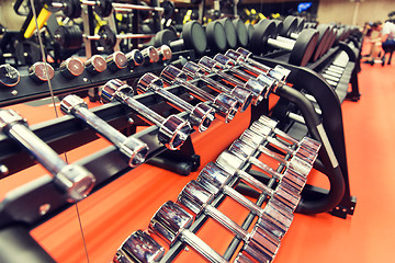 Image showing close up of dumbbells and sports equipment in gym