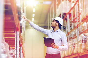 Image showing happy businessman with clipboard at warehouse