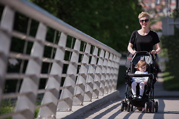 Image showing mother pushed her baby daughter in a stroller