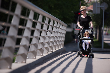 Image showing mother pushed her baby daughter in a stroller