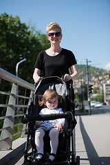 Image showing mother pushed her baby daughter in a stroller