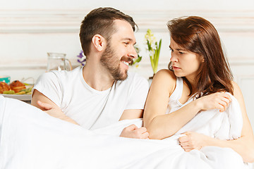 Image showing Young adult heterosexual couple lying on bed in bedroom