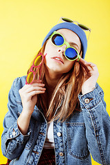 Image showing young pretty long hair teenage hipster girl posing emotional happy smiling on yellow background, lifestyle people concept