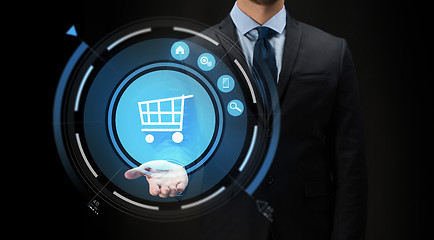 Image showing businessman with virtual shopping cart projection