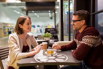 Image showing happy couple eating cake for dessert at cafe