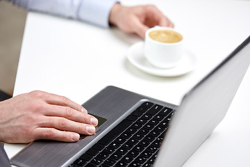 Image showing close up of male hands with laptop and coffee cup