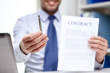 Image showing businessman with contract paper and pen at office