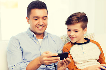 Image showing happy father and son with smartphone at home