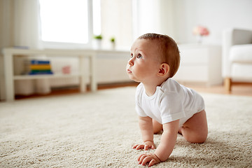 Image showing little baby in diaper crawling on floor at home