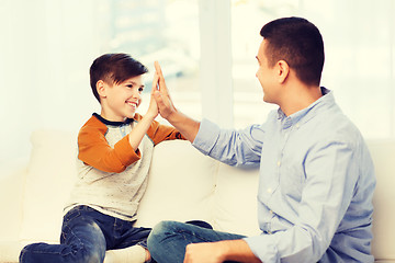 Image showing happy father and son doing high five at home