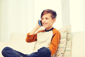 Image showing happy boy calling on smartphone at home