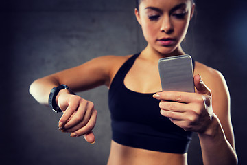 Image showing woman with heart-rate watch and smartphone in gym