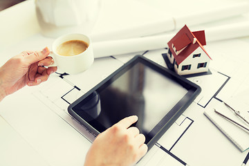 Image showing close up of hand with blueprint and tablet pc