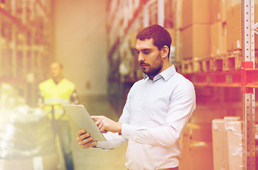 Image showing businessman with tablet pc at warehouse